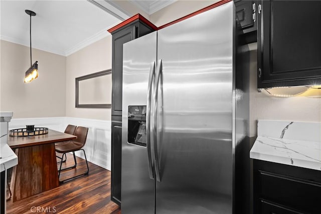 kitchen with hanging light fixtures, stainless steel fridge with ice dispenser, light stone countertops, dark hardwood / wood-style floors, and ornamental molding