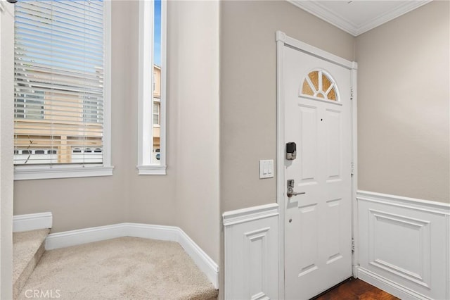 carpeted entryway featuring ornamental molding