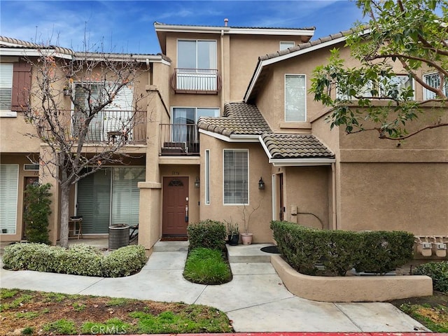 townhome / multi-family property featuring a balcony and central air condition unit