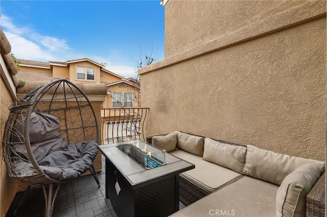 balcony featuring an outdoor living space with a fire pit