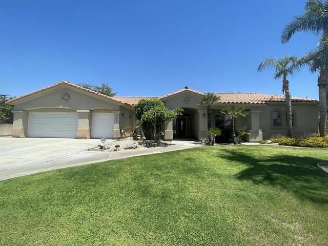 mediterranean / spanish home featuring a garage and a front yard