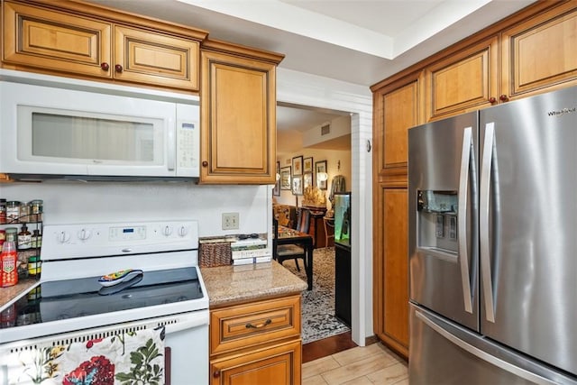 kitchen with light stone counters and white appliances