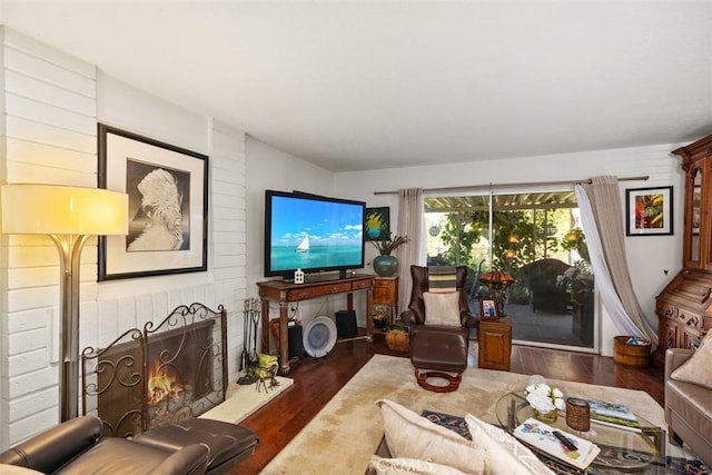 living room with dark hardwood / wood-style flooring and a fireplace