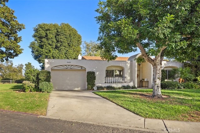 mediterranean / spanish home with a garage and a front lawn