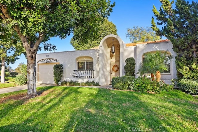 mediterranean / spanish-style house with a garage and a front yard