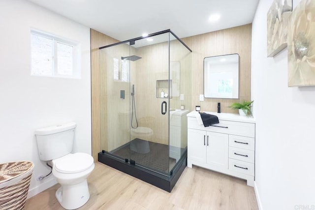 bathroom featuring hardwood / wood-style flooring, toilet, vanity, and walk in shower