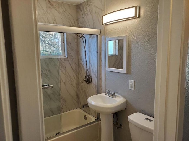 bathroom with tiled shower / bath, a healthy amount of sunlight, and toilet