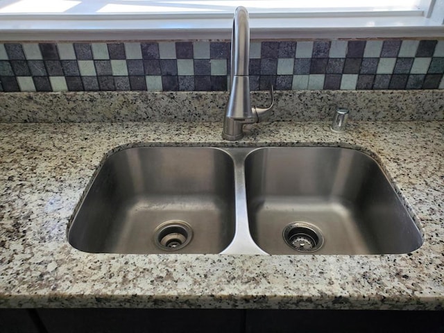 details featuring light stone countertops and sink