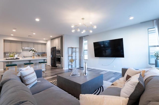 living room featuring an inviting chandelier and dark hardwood / wood-style flooring