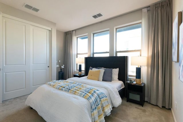 bedroom featuring light colored carpet and a closet