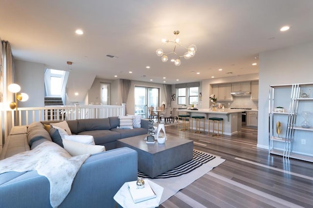 living room featuring dark wood-type flooring and a notable chandelier