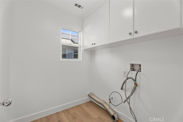 laundry room with cabinets, light hardwood / wood-style flooring, and washer hookup