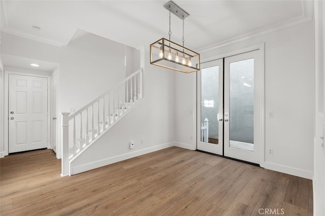 interior space with light hardwood / wood-style floors, crown molding, and french doors