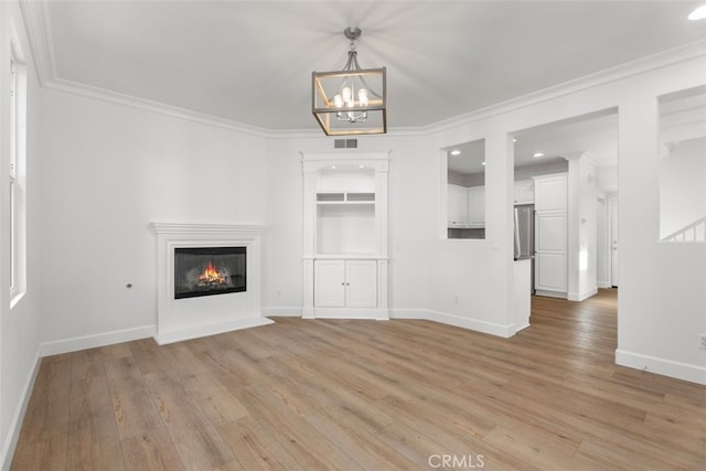 unfurnished living room with light hardwood / wood-style flooring, crown molding, and a chandelier