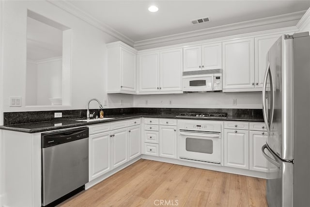 kitchen with sink, crown molding, white cabinets, and appliances with stainless steel finishes