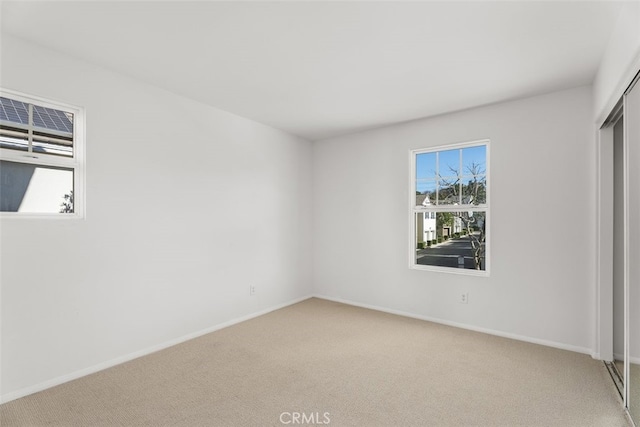 unfurnished bedroom featuring light colored carpet and a closet