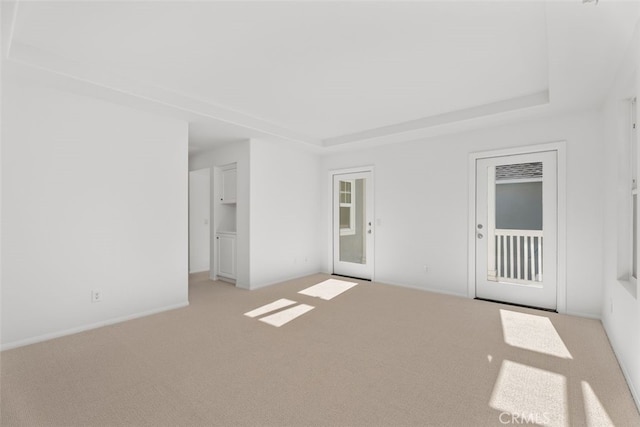 carpeted spare room with a tray ceiling