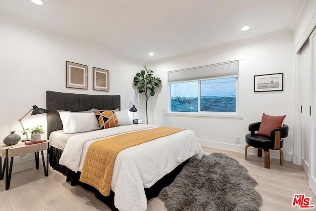 bedroom featuring ornamental molding and light hardwood / wood-style flooring