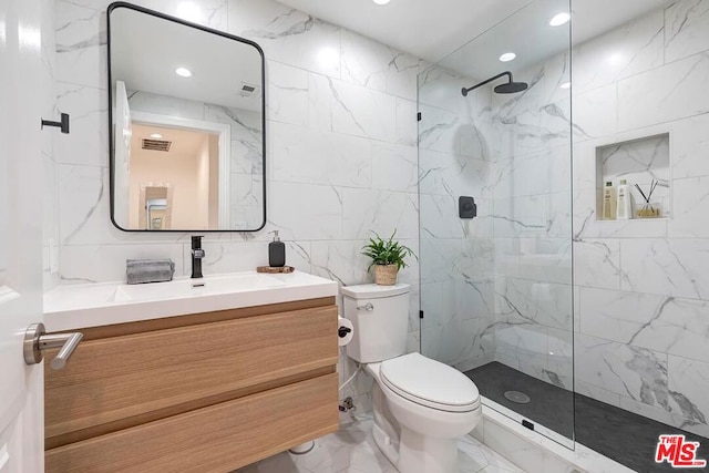 bathroom with vanity, tiled shower, tile walls, and toilet