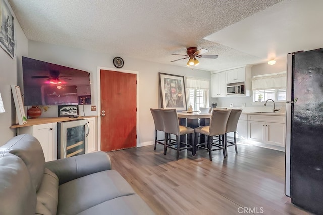 living room featuring wet bar, plenty of natural light, wine cooler, and a textured ceiling