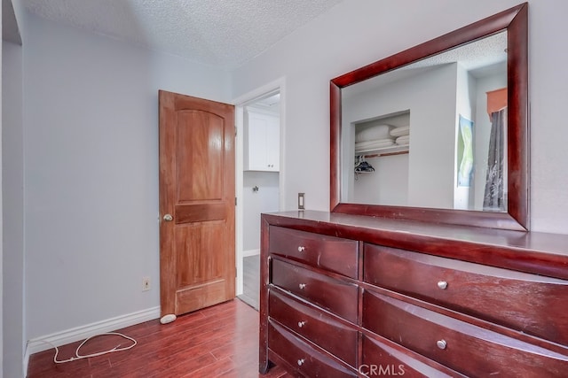 bedroom featuring a textured ceiling, a closet, and hardwood / wood-style floors