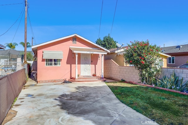 view of front of house with a front yard and a patio