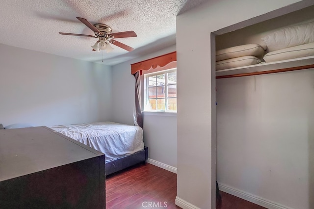 unfurnished bedroom featuring ceiling fan, dark wood-type flooring, and a textured ceiling