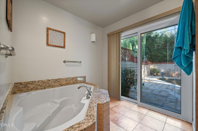 bathroom with tiled tub and tile patterned floors