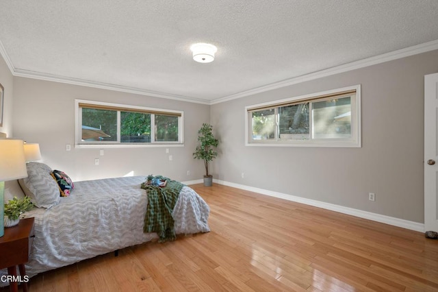 bedroom with a textured ceiling, light hardwood / wood-style flooring, and ornamental molding