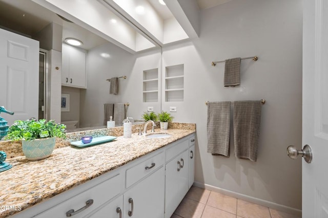 bathroom featuring toilet, vanity, and tile patterned flooring