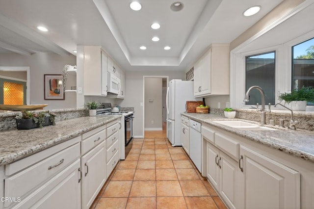 kitchen with sink, white cabinets, light tile patterned floors, light stone counters, and white appliances