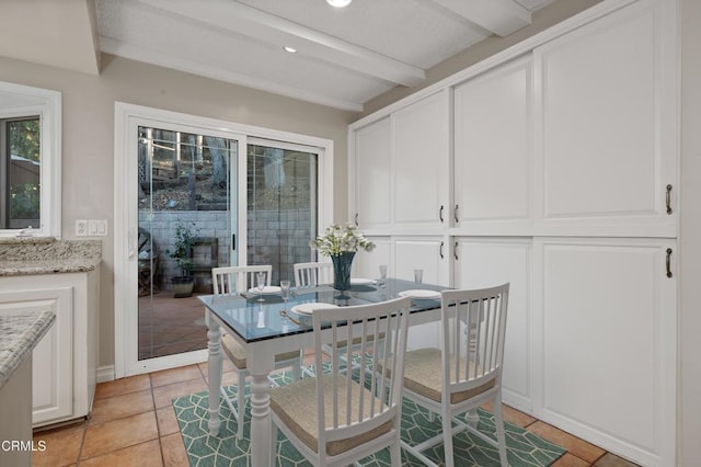 dining area featuring beamed ceiling and light tile patterned flooring