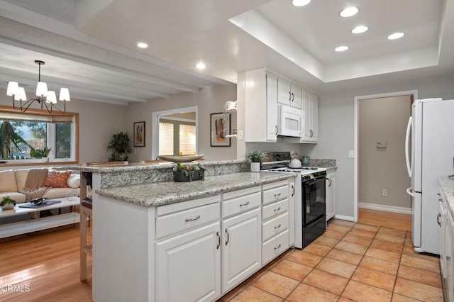 kitchen featuring kitchen peninsula, white appliances, and a breakfast bar area