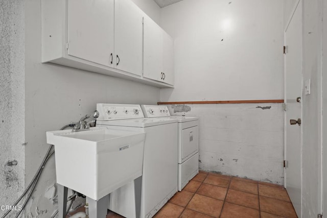 laundry area with sink, cabinets, light tile patterned floors, and separate washer and dryer