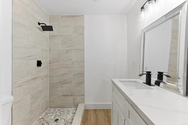 bathroom featuring vanity, tiled shower, and hardwood / wood-style floors