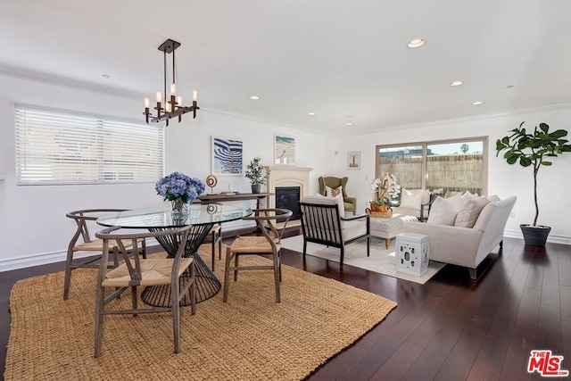 dining space with an inviting chandelier, crown molding, and dark hardwood / wood-style flooring