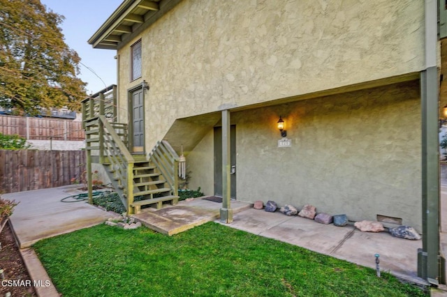 entrance to property with a patio and a lawn