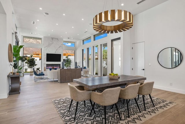 dining area with a premium fireplace and light wood-type flooring