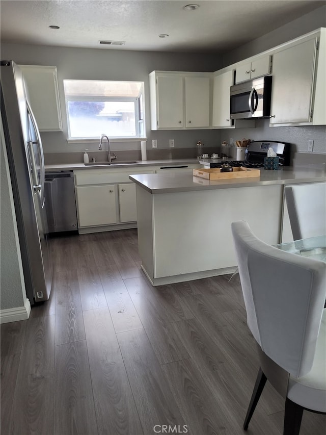 kitchen featuring sink, white cabinetry, appliances with stainless steel finishes, and dark hardwood / wood-style flooring