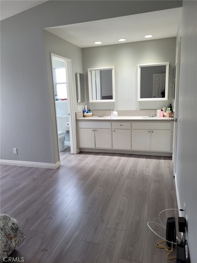 bathroom with wood-type flooring, toilet, and vanity