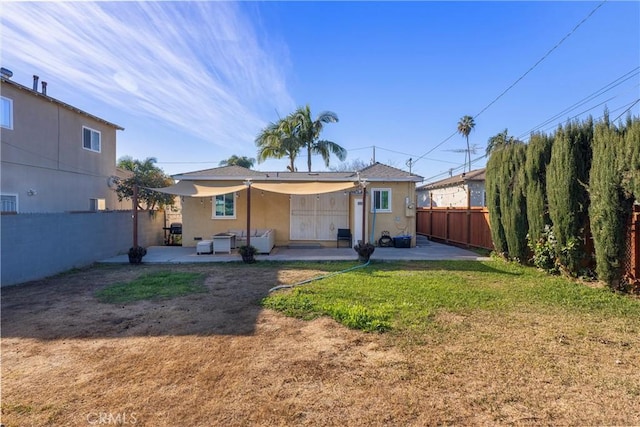 rear view of house with a yard and a patio area