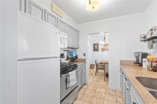 kitchen featuring an inviting chandelier, gray cabinetry, white appliances, and light tile patterned floors