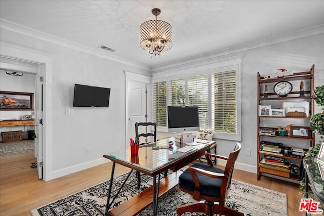 office with hardwood / wood-style floors, ornamental molding, and an inviting chandelier