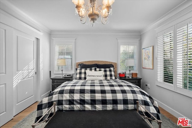 bedroom with crown molding, light hardwood / wood-style floors, and a notable chandelier