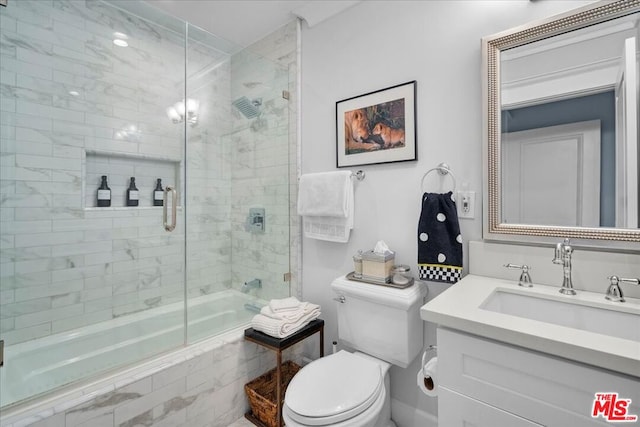 full bathroom featuring vanity, shower / bath combination with glass door, and toilet