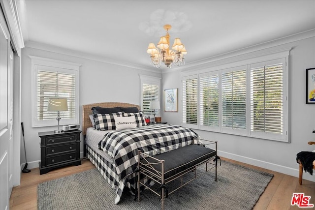 bedroom with crown molding, a chandelier, and light wood-type flooring