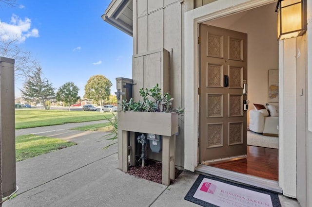 doorway to property featuring a lawn