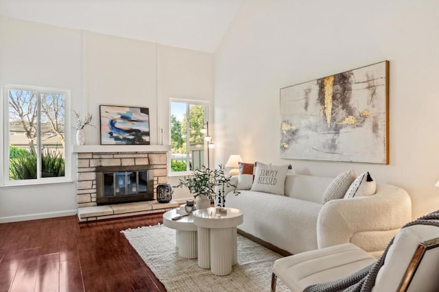 living room with a stone fireplace, high vaulted ceiling, and a wealth of natural light