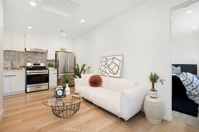 living room featuring sink and light hardwood / wood-style flooring