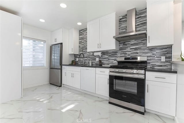 kitchen featuring sink, white cabinetry, wall chimney range hood, decorative backsplash, and stainless steel appliances